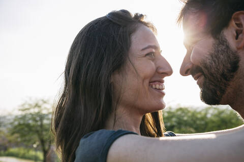 Young woman and man looking at each other against clear sky stock photo