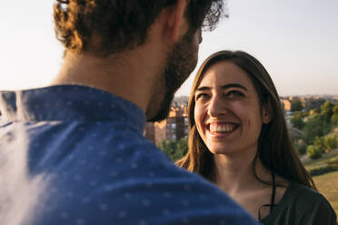 Beautiful woman looking at man while standing against clear sky - ABZF03324