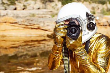 Astronaut taking photo from camera while standing on moon - JCMF01392