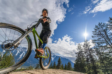 Frau beim Mountainbiking in einem Wald in den kanadischen Bergen - CUF56558