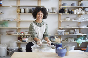 Portrait of smiling woman learning pottery in art studio - MASF19563