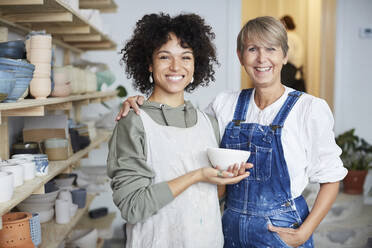 Portrait of smiling females with bowl in pottery class - MASF19595