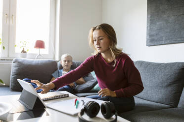 Teenager benutzt digitales Tablet, während sein Bruder zu Hause telefoniert - MASF19711