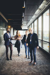 Female and male entrepreneurs walking in office corridor - MASF19791