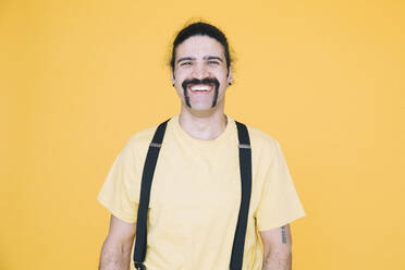 Porträt eines glücklichen reifen Mannes vor gelbem Hintergrund - MASF19829