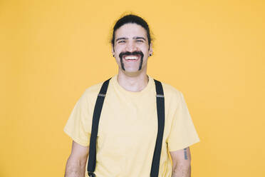 Portrait of happy mature man against yellow background - MASF19829