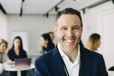 Portrait of happy businessman in office - MASF19865