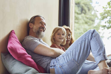 Parents with daughter relaxing on bed at home - MCF01353