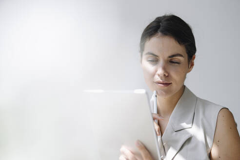 Thoughtful businesswoman using digital tablet at office - KNSF08448