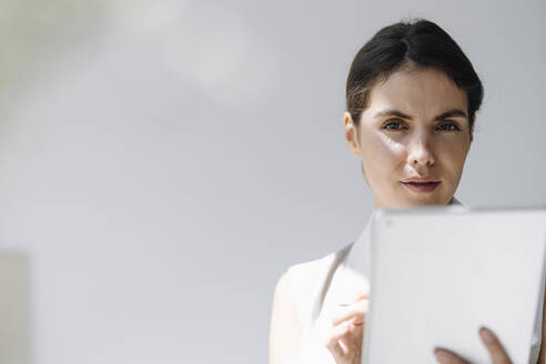 Businesswoman using digital tablet at office - KNSF08449