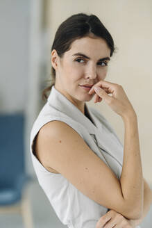 Young woman looking away while standing at office - KNSF08494