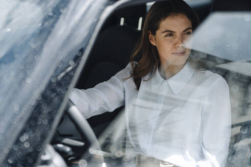 Businesswoman looking away while sitting in car - KNSF08517