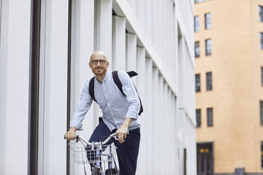 Man riding bicycle on street in city - MCF01491