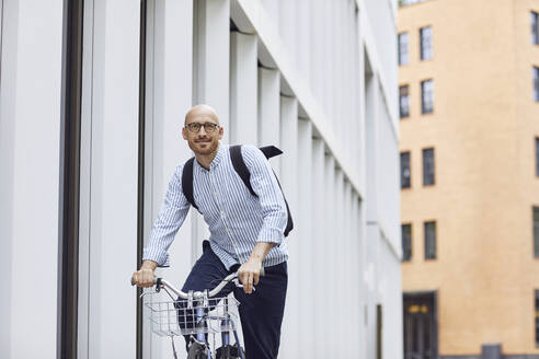 Mann fährt Fahrrad auf der Straße in der Stadt - MCF01491