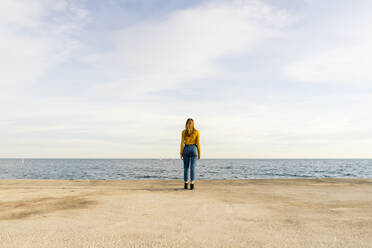 Young woman standing by sea against sky - AFVF07264