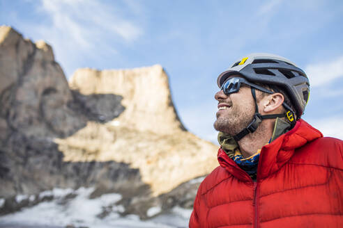 Lächelndes Porträt eines Bergsteigers in der Seitenansicht unterhalb des Gipfels. - CAVF88792