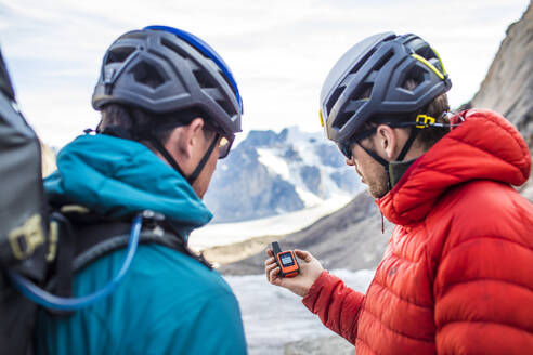 Zwei Bergsteiger verwenden ein GPS, um sich im Gebirge zurechtzufinden. - CAVF88793