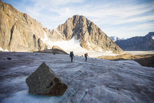 Rückansicht von zwei Bergsteigern, die einen Berggletscher überqueren. - CAVF88795