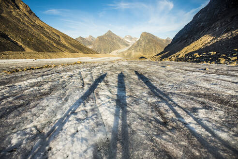 Schatten von drei Forschern auf einem Gletscher in den Bergen. - CAVF88813