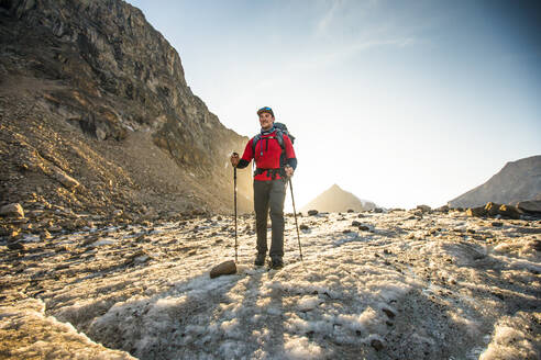 Abendlicht auf einen Bergsteiger, der über einen Gletscher wandert. - CAVF88814