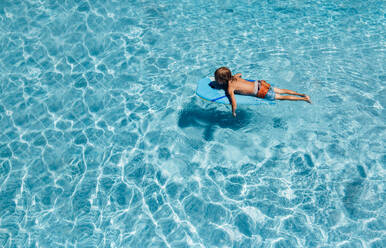 Kleiner Junge schwimmt an einem Sommertag im Pool - CAVF88844