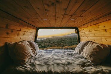 Sunset view of ocean over cliffs from bed of sprinter van in Mexico. - CAVF88848