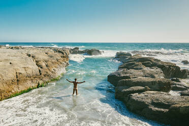 Young man swimming in Pacific Ocean swimming hole in Baja, Mexico. - CAVF88856