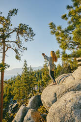 Junge Frau beim Fotografieren des Sonnenuntergangs über dem Lake Tahoe. - CAVF88885