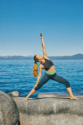 Young woman practicing yoga on Lake Tahoe in northern California. - CAVF88889