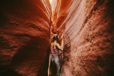 Junge Frau erkundet im Sommer enge Slot Canyons in Escalante - CAVF88921