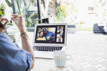 Woman video chatting with friends on laptop screen - CAIF29514