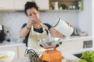 Woman weighing flour on scales – License Images – 330715 ❘ StockFood