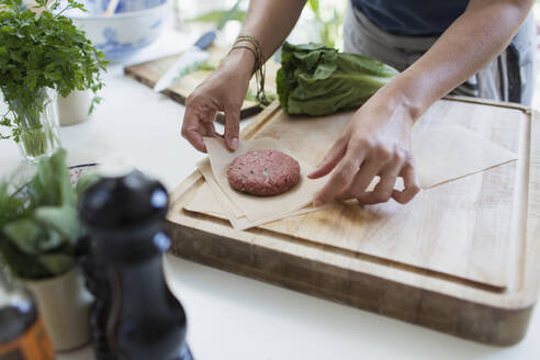 Frau macht frische Hamburger-Patties auf Schneidebrett - CAIF29611