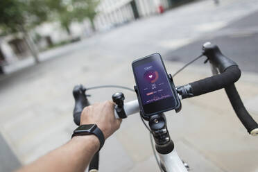 POV man riding bicycle with smart phone health monitor - CAIF29674