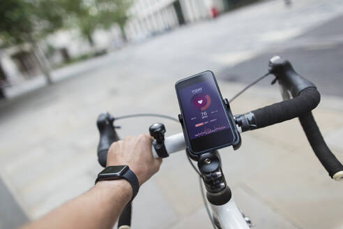 POV Mann fährt Fahrrad mit Smartphone-Gesundheitsmonitor - CAIF29674