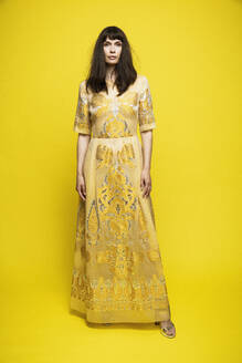 Reife Frau im Kleid vor gelbem Hintergrund - DHEF00392