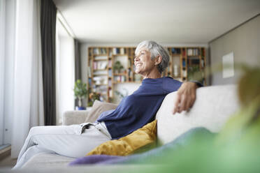 Ältere Frau sitzt zu Hause auf dem Sofa - RBF07808