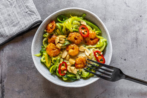 Nahaufnahme von Zoodles mit Shrimps und Chili in einer Schüssel auf dem Tisch - SARF04627