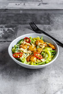 Nahaufnahme von Zoodles mit Shrimps und Chili in einer Schüssel auf dem Tisch - SARF04628