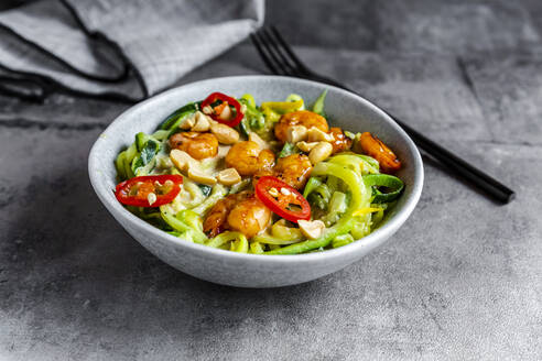 Nahaufnahme von Zoodles mit Shrimps und Paprika in einer Schüssel auf dem Tisch - SARF04629