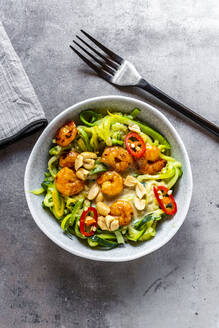 Zoodles mit Shrimps und Chili in einer Schüssel auf dem Tisch serviert - SARF04631