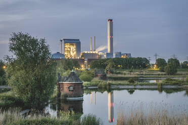 Deutschland, Hamburg, Pumpenhaus des ehemaligen Wasserwerks auf der Elbinsel Kaltehofe mit Tiefstack-Kraftwerk im Hintergrund in der Abenddämmerung - KEBF01660