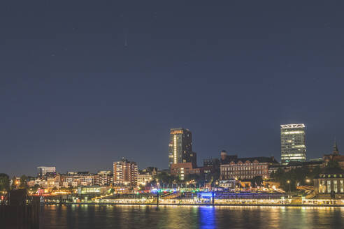 Deutschland, Hamburg, St. Pauli Gebäude beleuchtet in der Nacht über die Elbe gesehen - KEBF01685