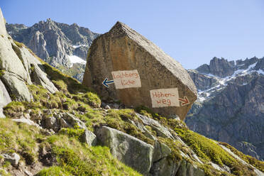 Wegkreuzungstafel auf Felsblock gemalt, Furkapass, Uri, Schweiz - CAVF88998