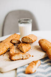 Frisch gebackene Kekse und ein Glas Milch auf dem Tisch - CAVF89064