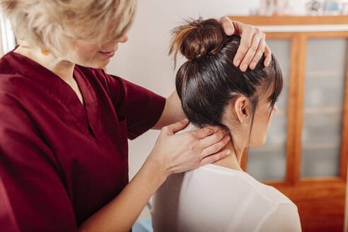 Physiotherapist massaging woman neck - MRRF00449