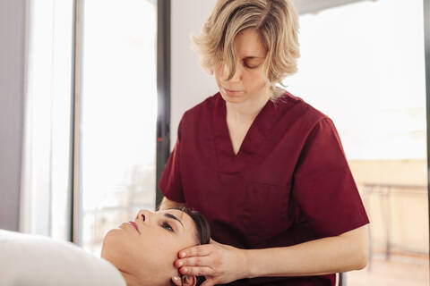 Physiotherapist massaging woman head stock photo