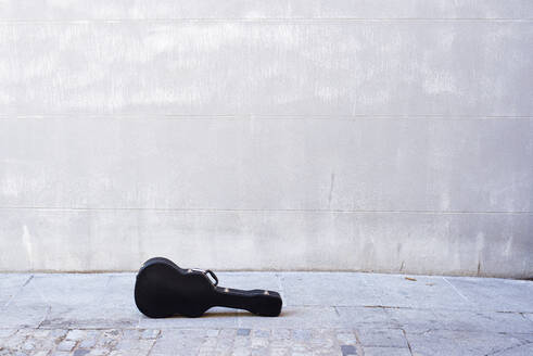 Gitarre auf der Straße gegen eine Betonwand in der Stadt gehalten - JCMF01407
