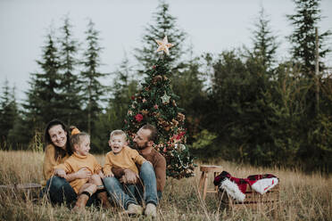 Familie feiert Weihnachten auf dem Lande bei Sonnenuntergang - GMLF00604