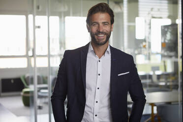 Man smiling while standing at office - RBF07881